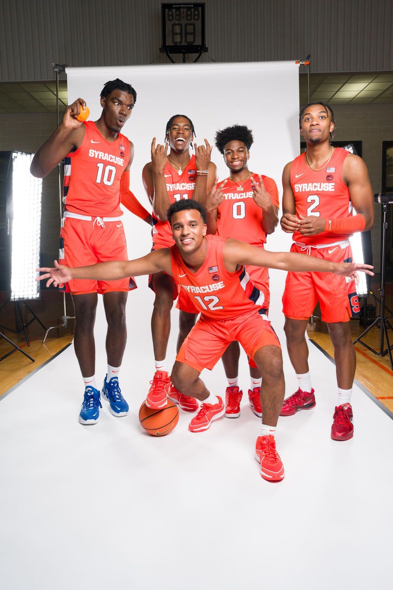Syracuse basketball team posing in orange uniforms.