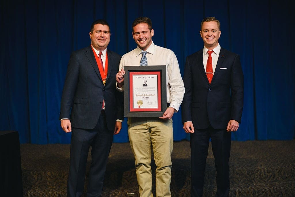 Three men celebrating an award ceremony together.