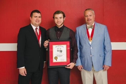 Three men celebrating an award ceremony.