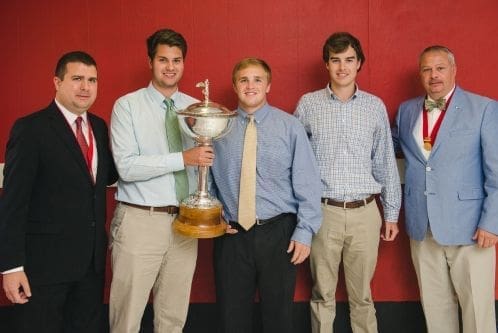 Group of young men holding a trophy.