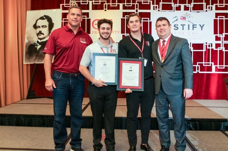 Award ceremony with four attendees holding certificates.