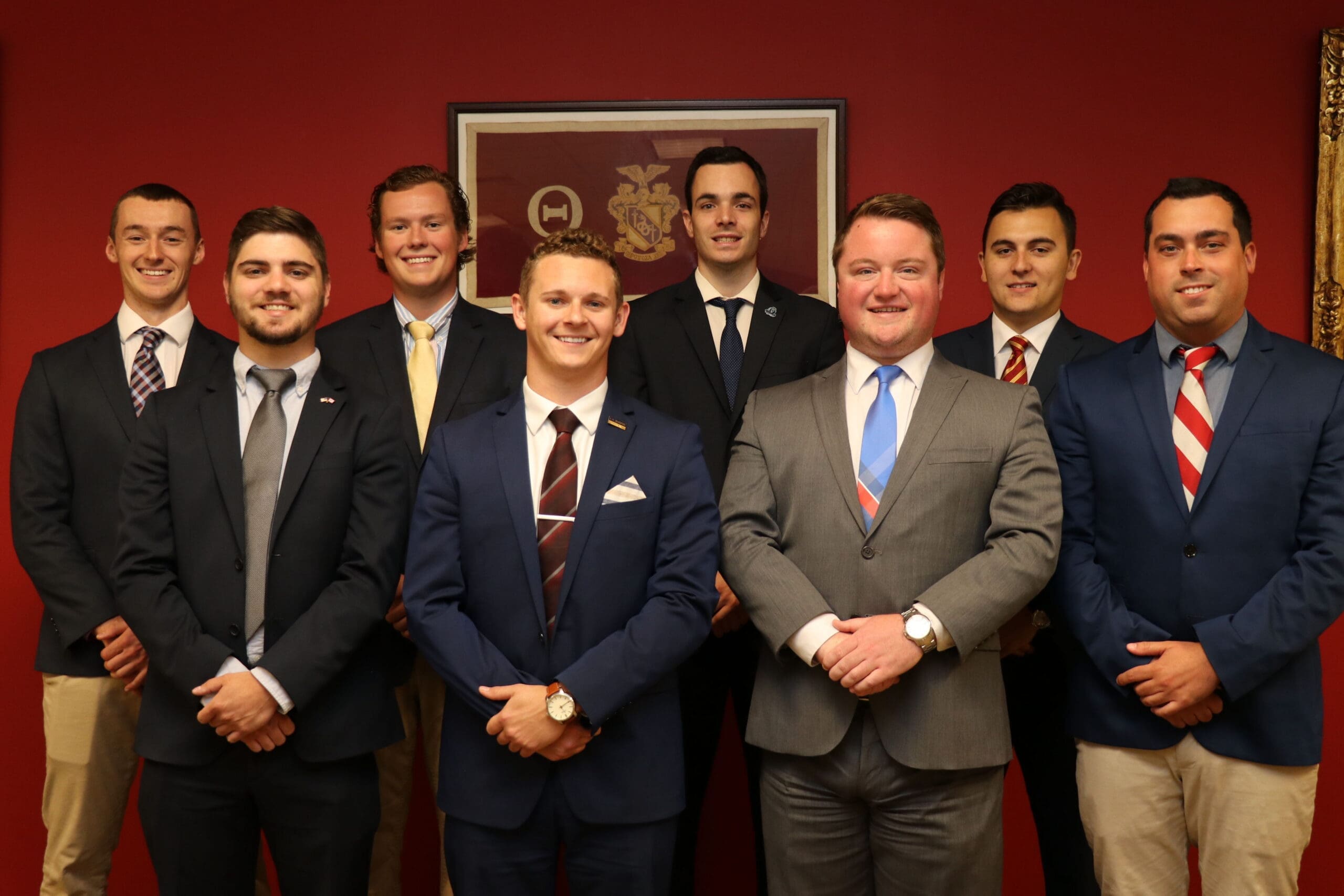 Group of professionals in formal attire posing together.