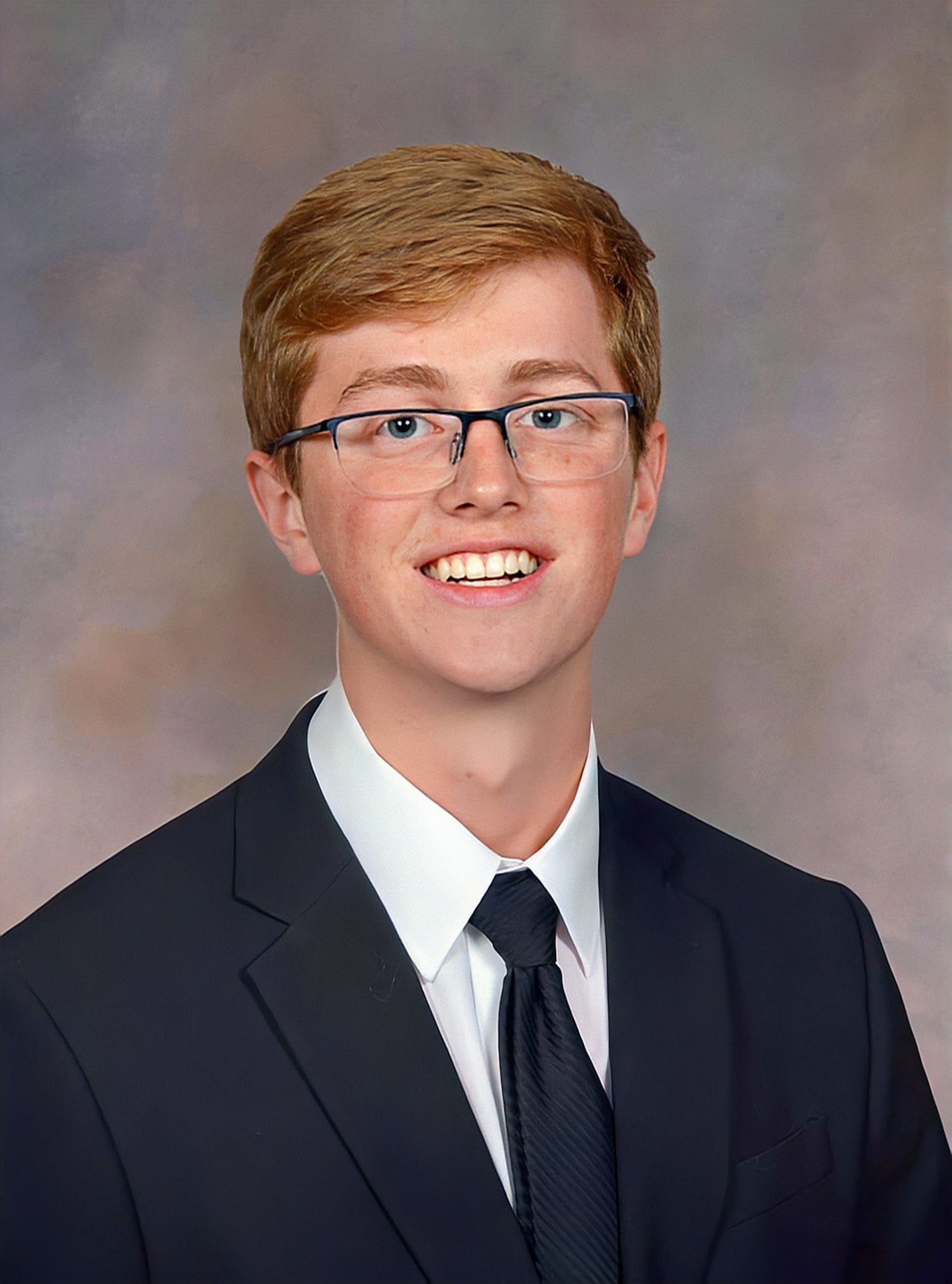 Smiling young man in formal attire portrait.