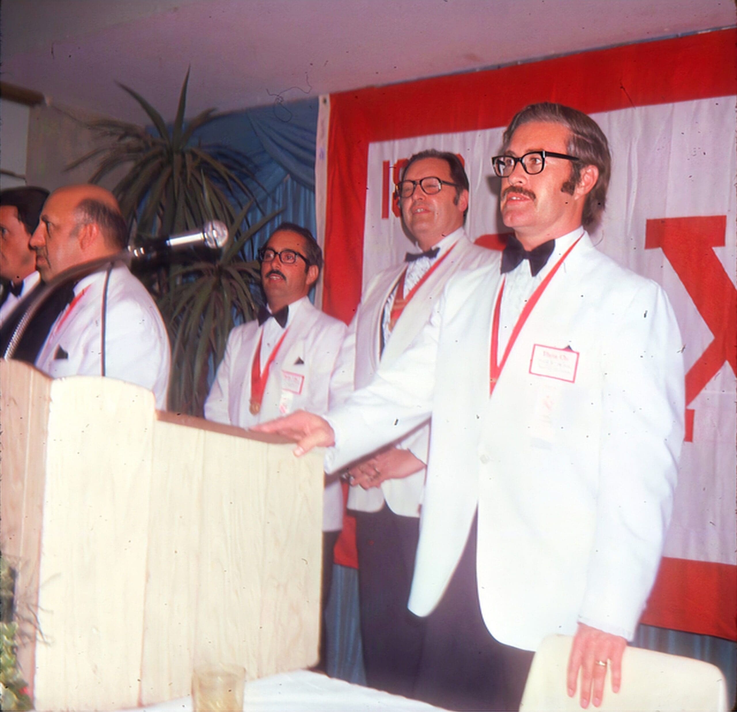 Men in white jackets at a formal event.