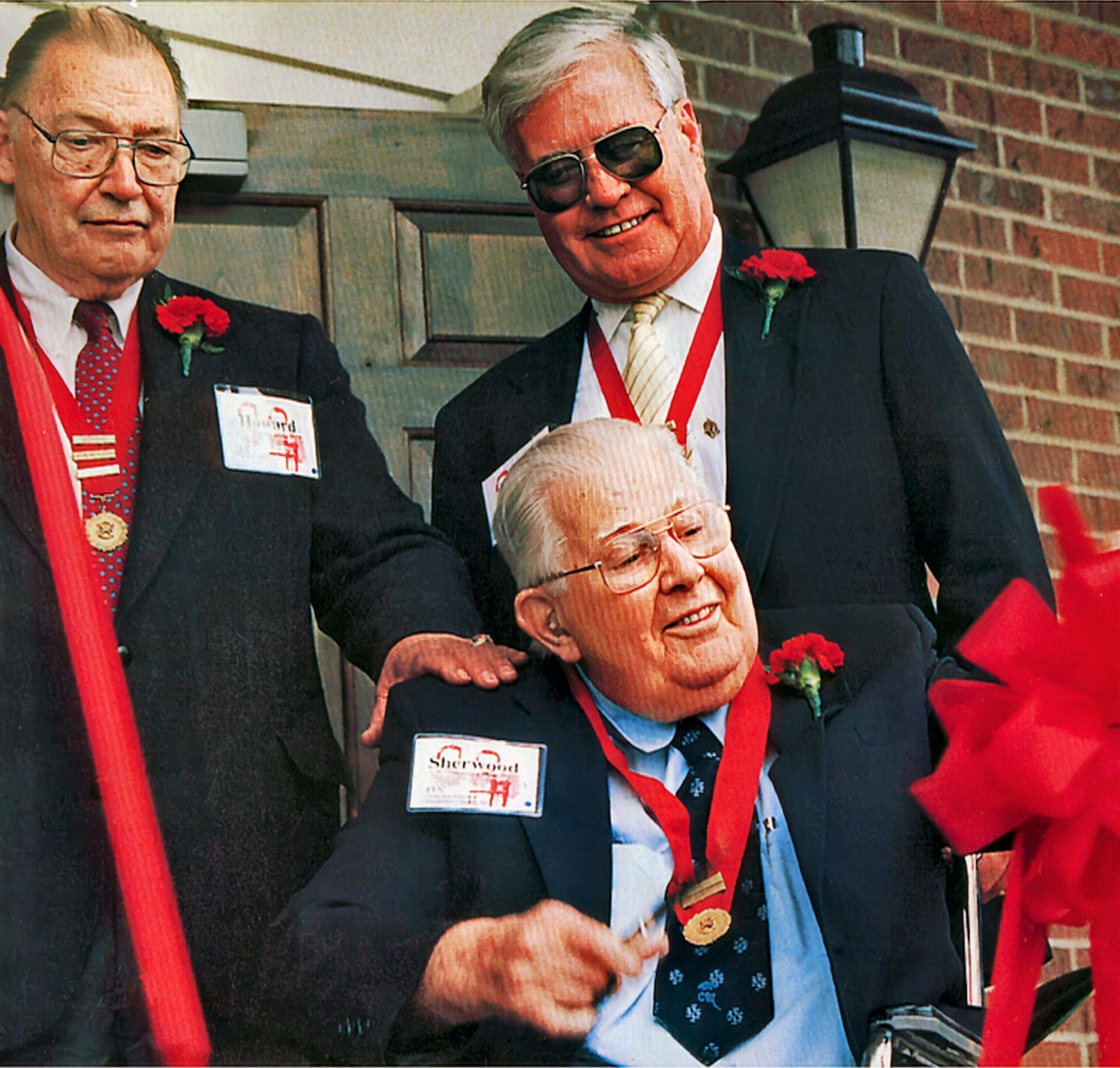 Three men celebrating an award ceremony together.
