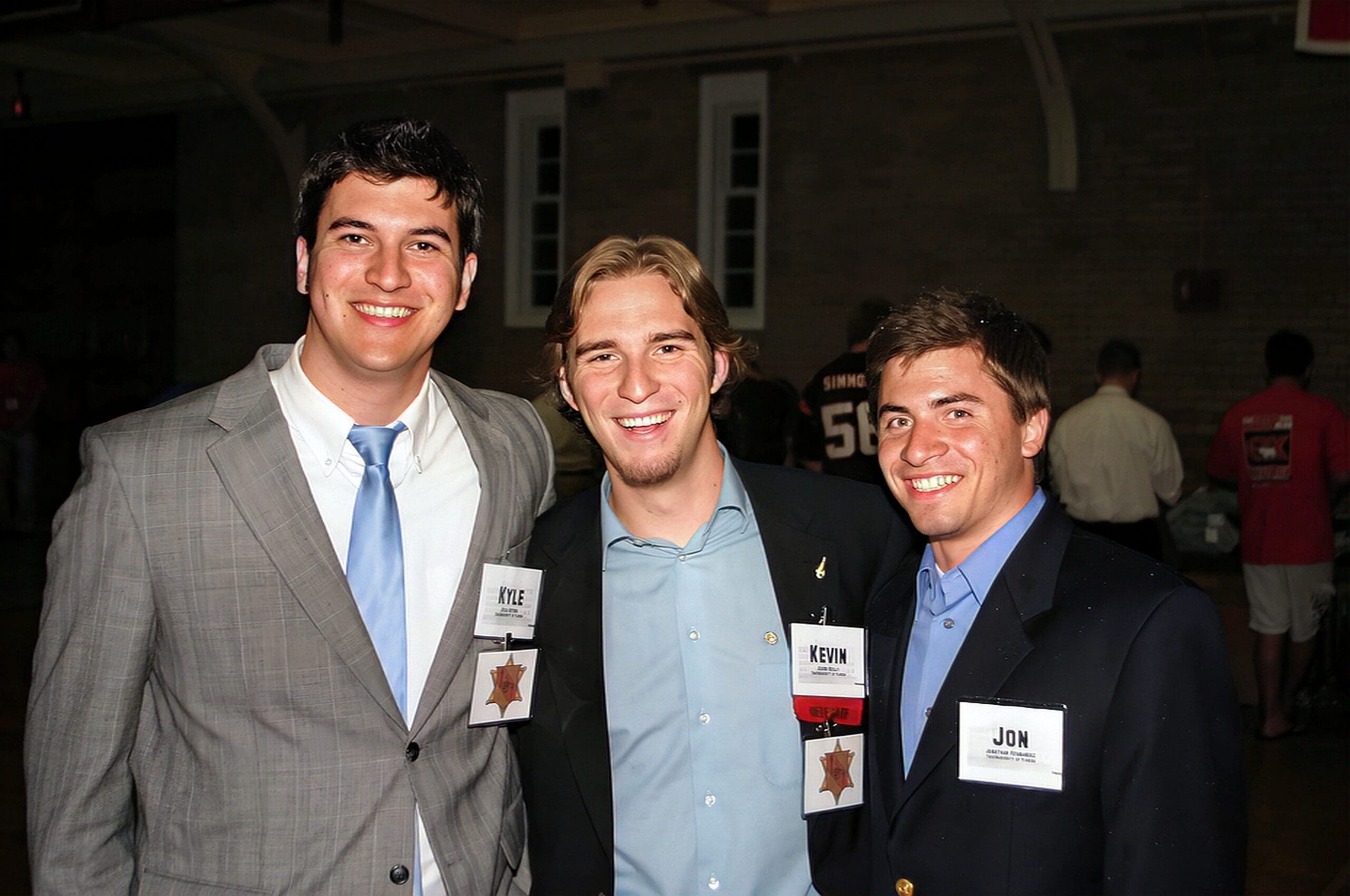 Three men posing together at a social event.