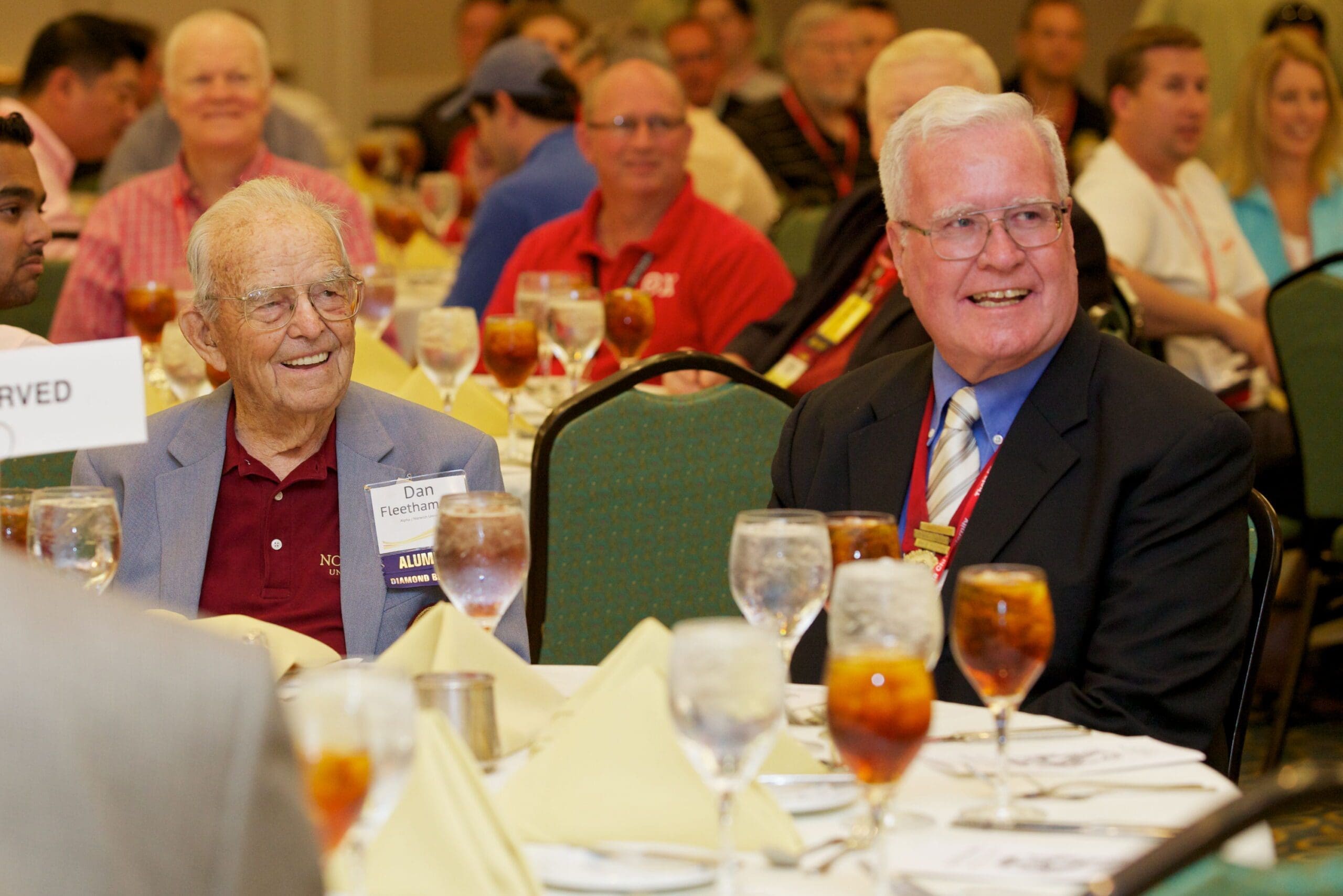 Two elderly men enjoying a meal at a gathering.