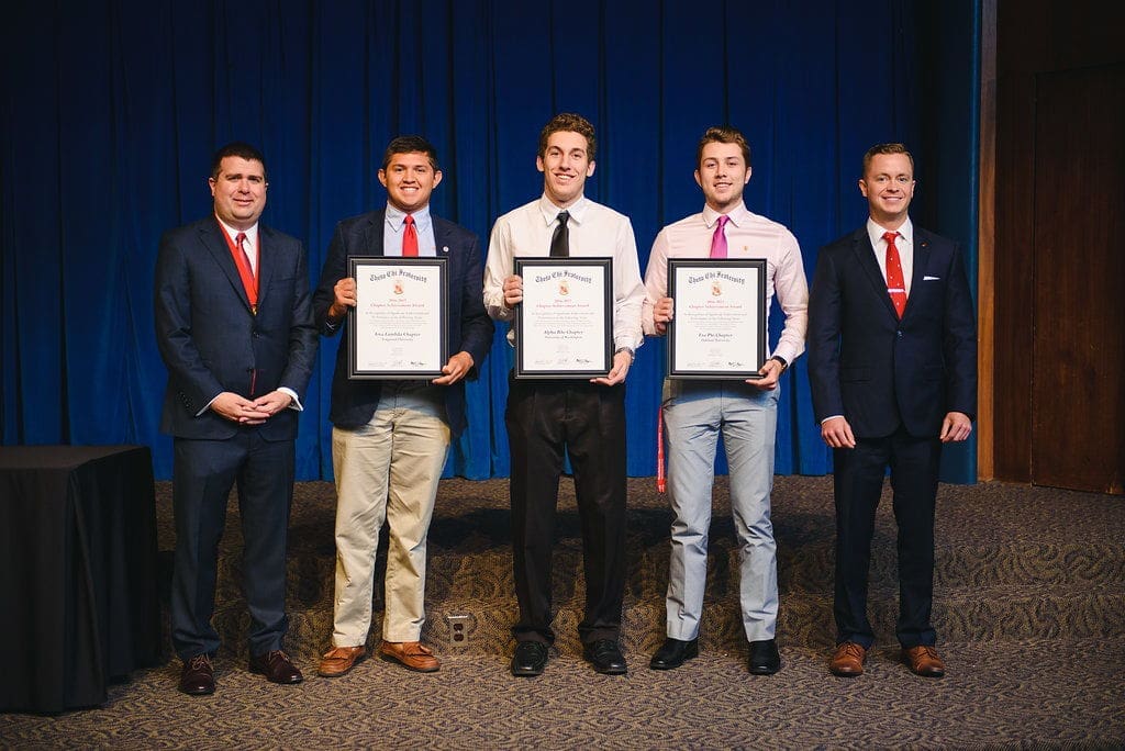 Students receiving awards at a formal ceremony.