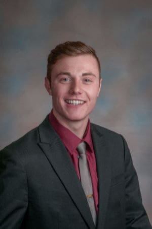 Smiling young man in a formal suit and tie.
