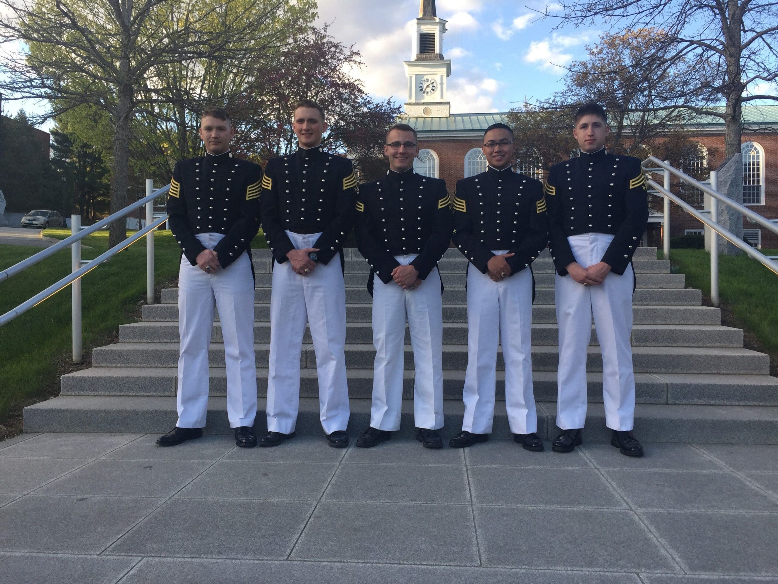 Cadets in uniform standing on steps outdoors.
