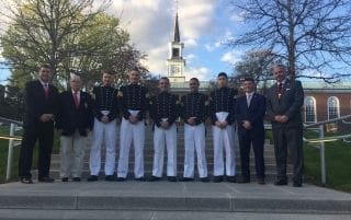 Military cadets in uniform with faculty outdoors.