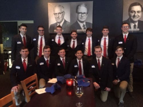 Group of young men in formal attire at dinner.