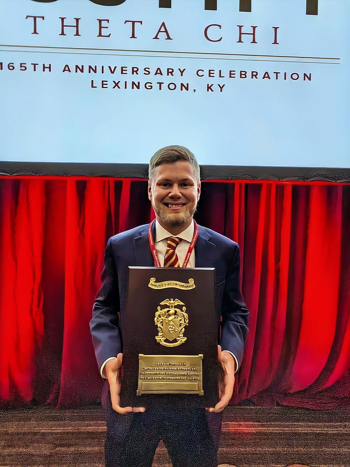 Hunter Smith Man holding award at 165th anniversary celebration in Lexington.