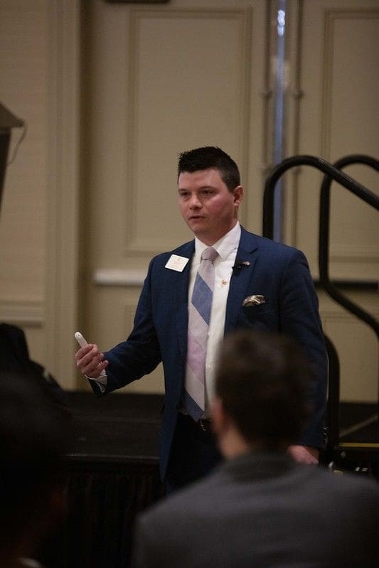 Speaker presenting at a professional event.