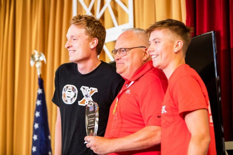 Award ceremony with three smiling participants.