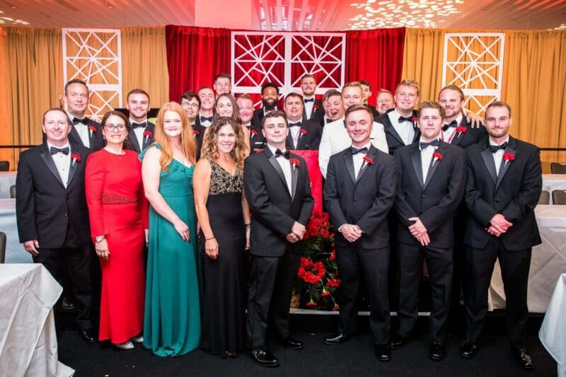 Group photo at formal event with attendees in tuxedos.