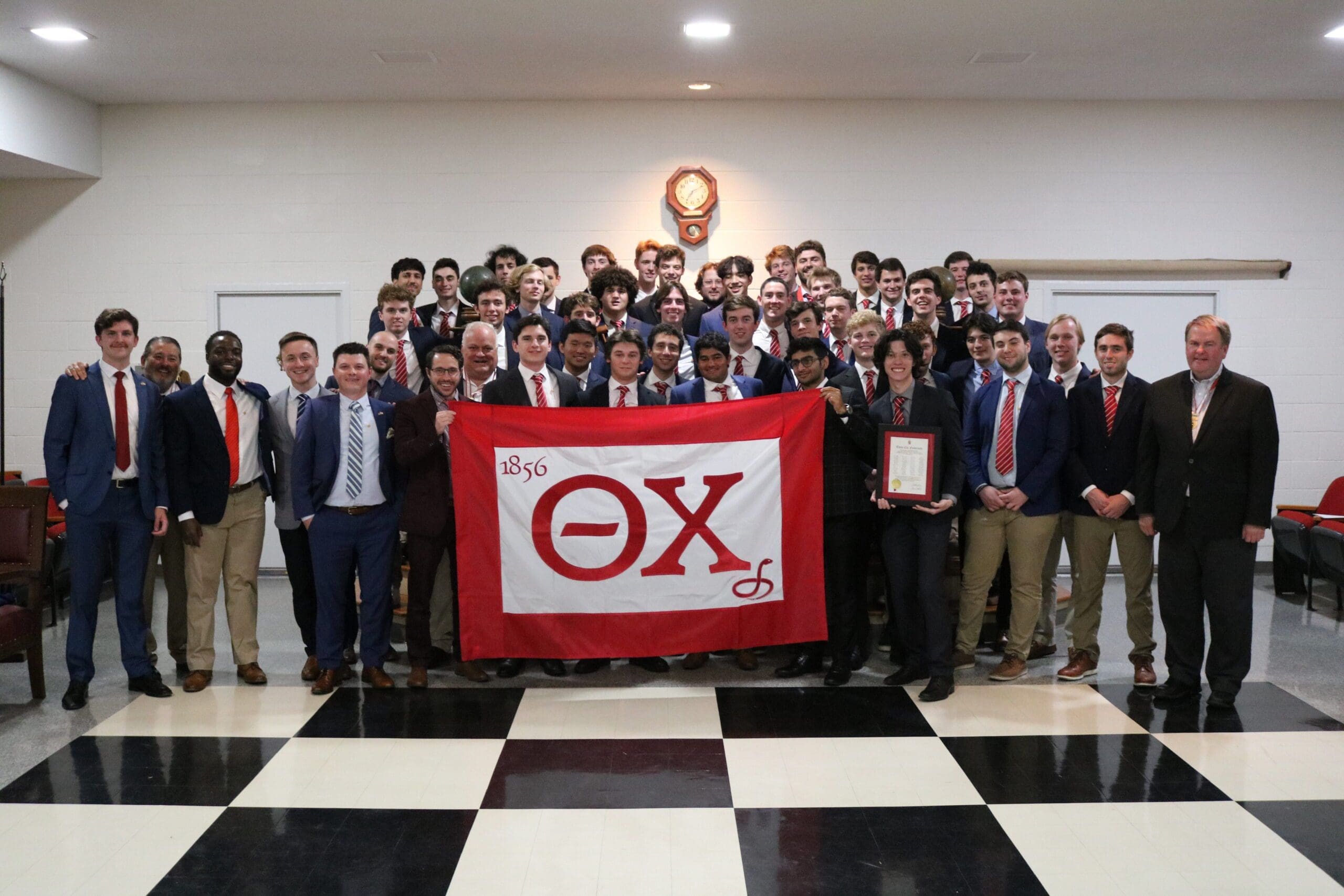 Group photo of fraternity members holding banner.