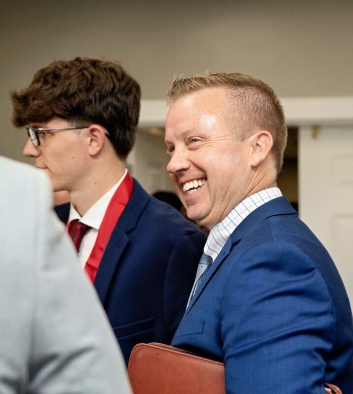 Smiling man in blue suit at event.