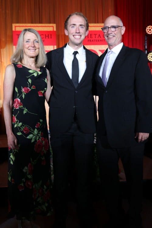 Three people posing together at an event.
