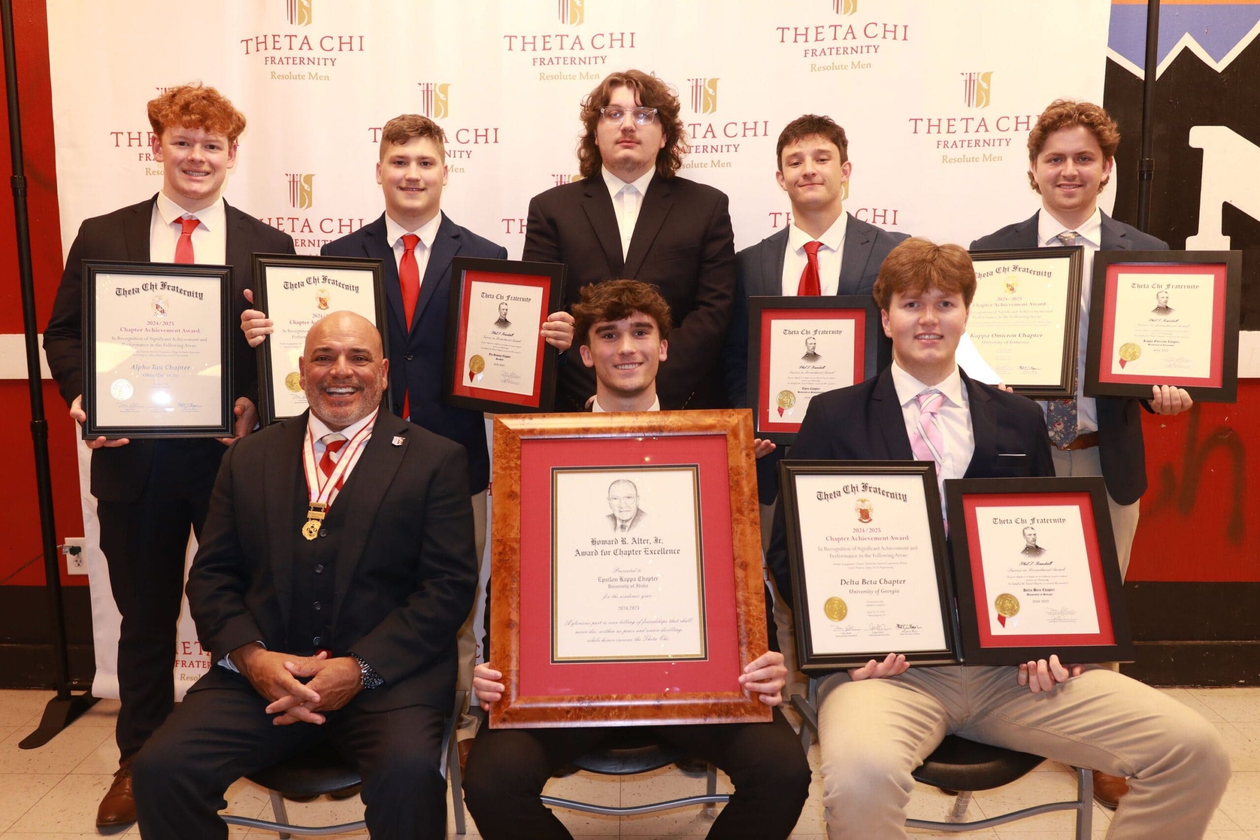 Theta Chi fraternity members with awards and certificates.