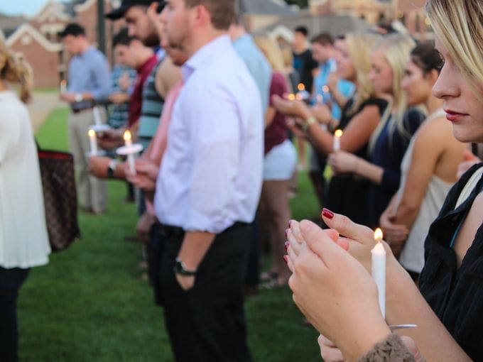 Candlelight vigil with attendees holding candles.