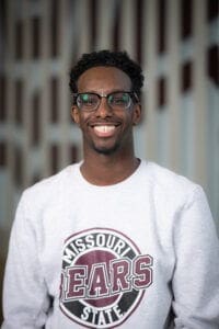 Smiling student wearing Missouri State sweatshirt outdoors.