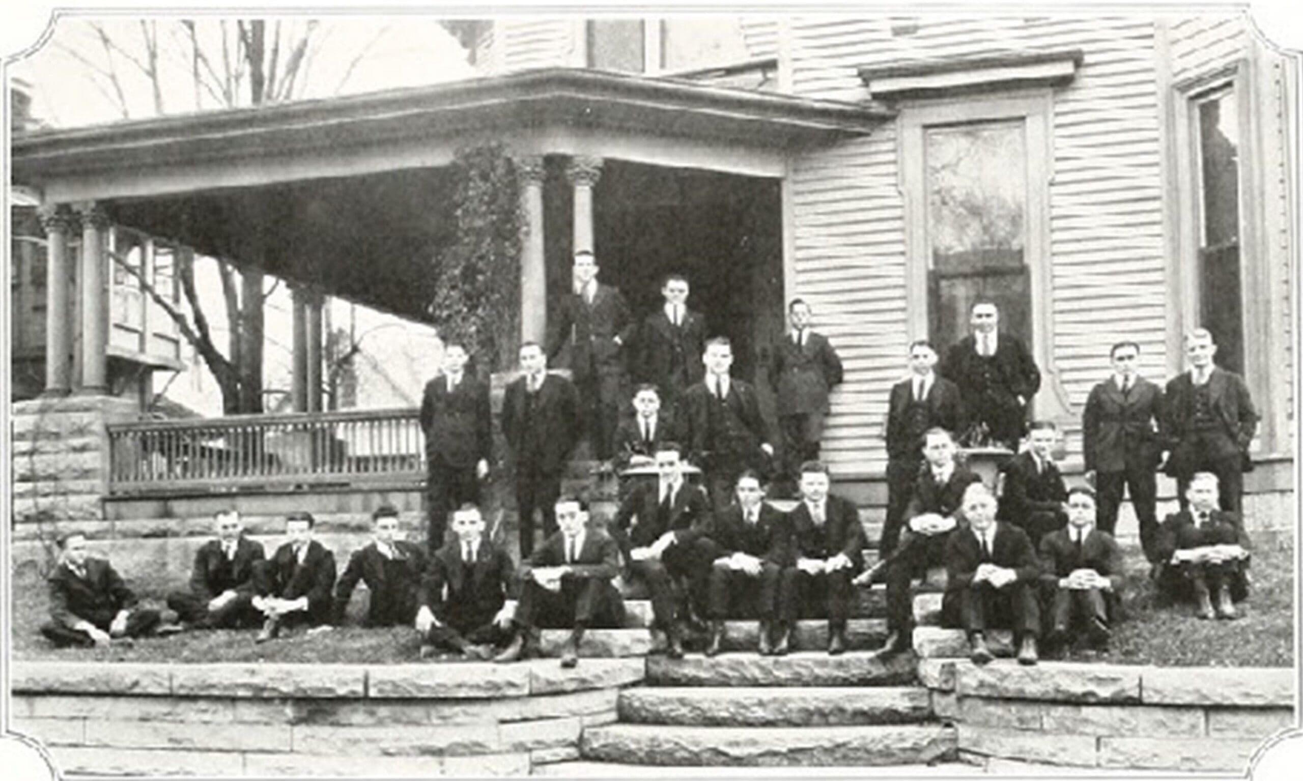 Alpha Iota - Indiana Group of men in formal attire on porch steps.