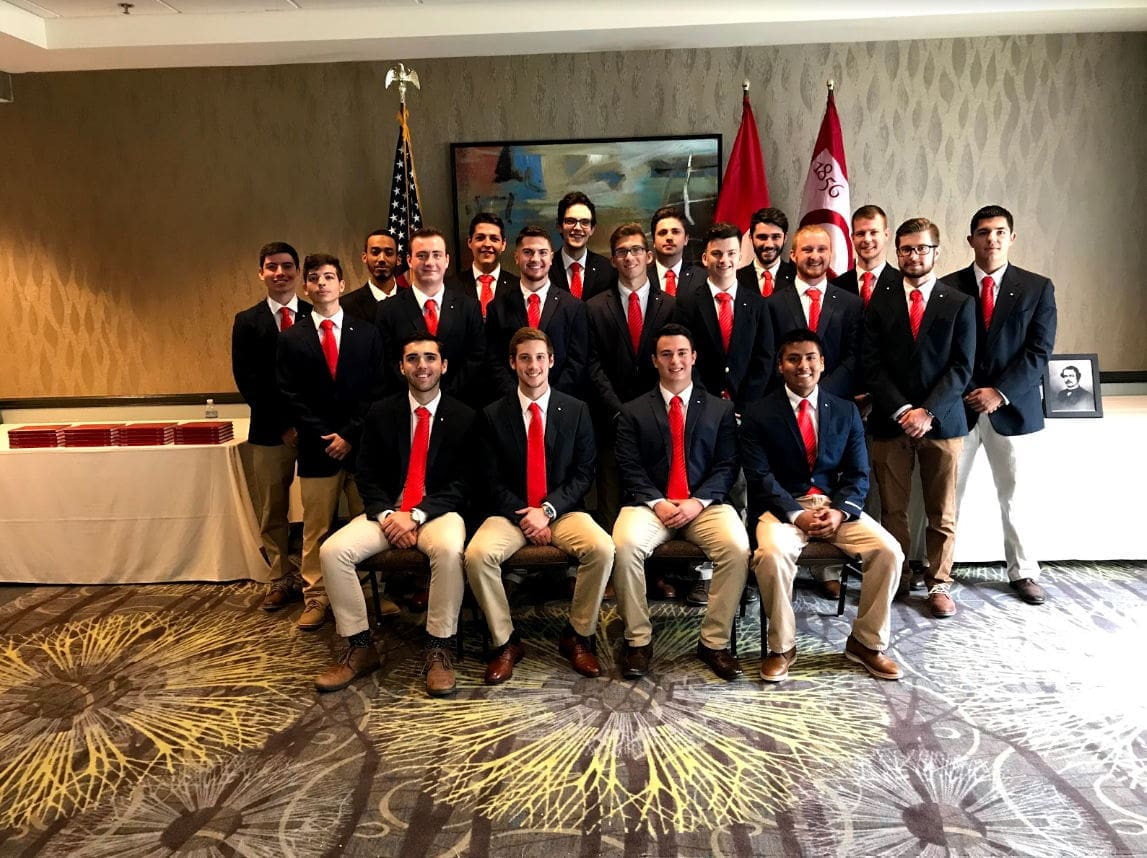 Group photo of men in suits with red ties.