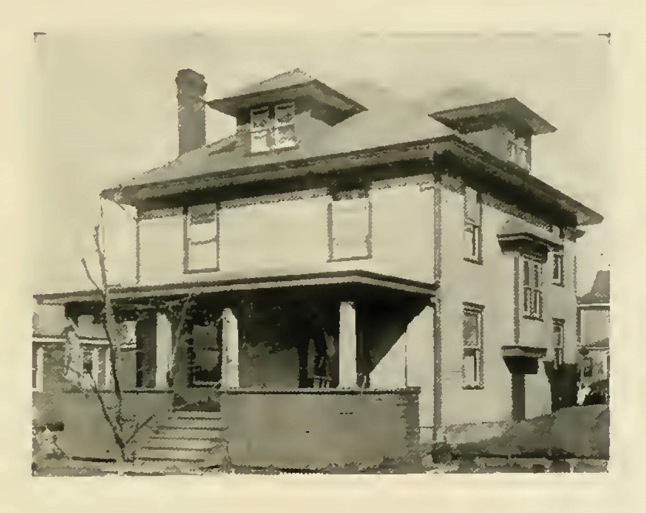 Historic two-story house with porch and gabled roof.