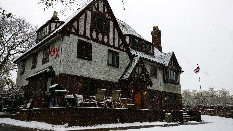 Snow-covered traditional Tudor-style house exterior.