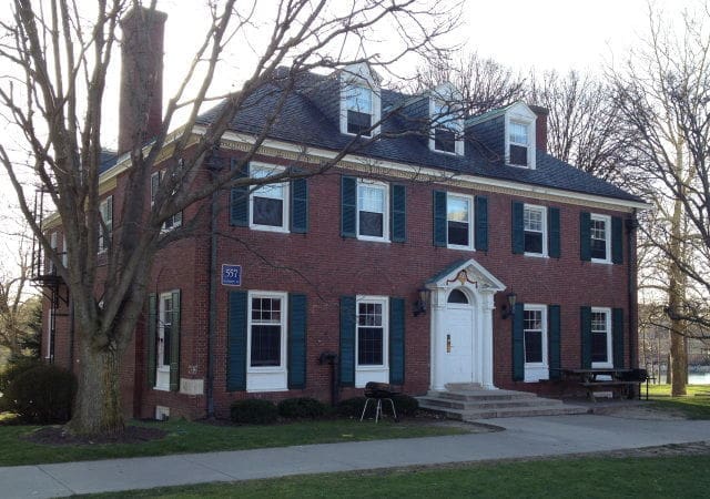 Brick house with blue shutters and front porch.