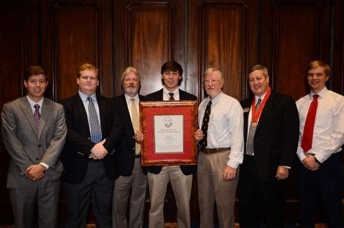 Group of men holding a framed certificate together.