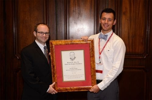 Two men holding an award plaque.
