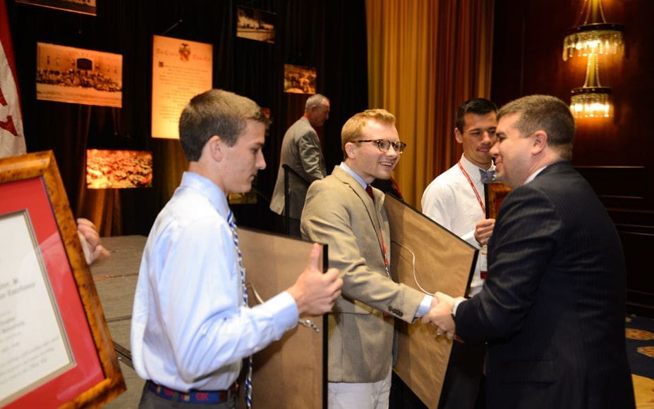Students receiving awards at a formal event.