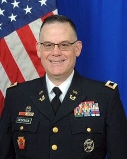 Bob DeSousa Military officer portrait with American flag background.