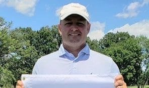 Man holding a sign outdoors on a sunny day.
