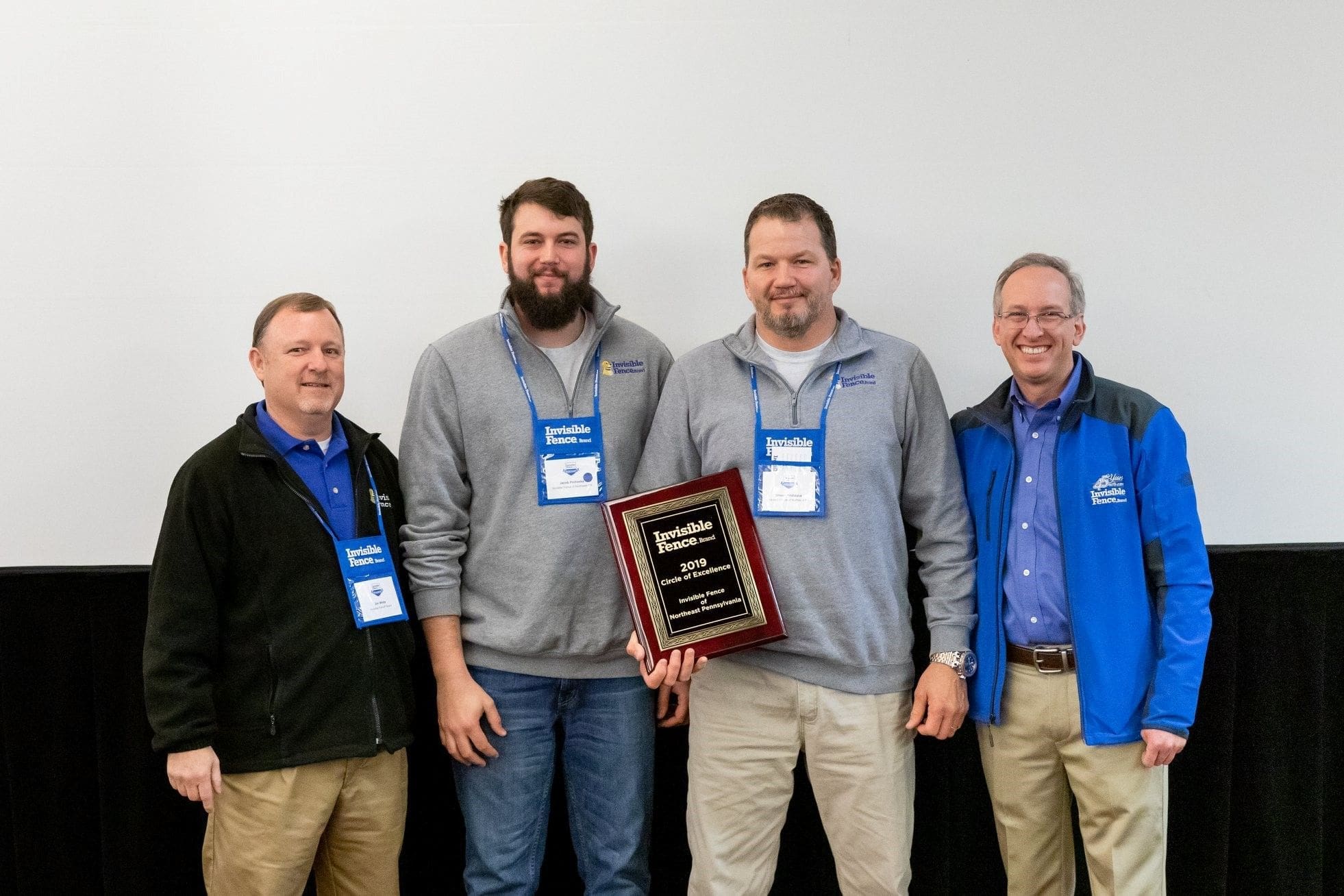 Shawn Prohaska Four men holding an award plaque at an event.