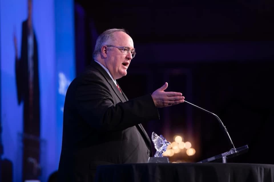 Man giving speech at an awards ceremony.