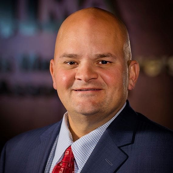 Professional man in suit smiling at camera.