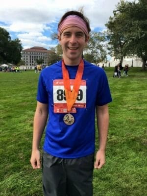 Runner celebrating with medal after race completion.