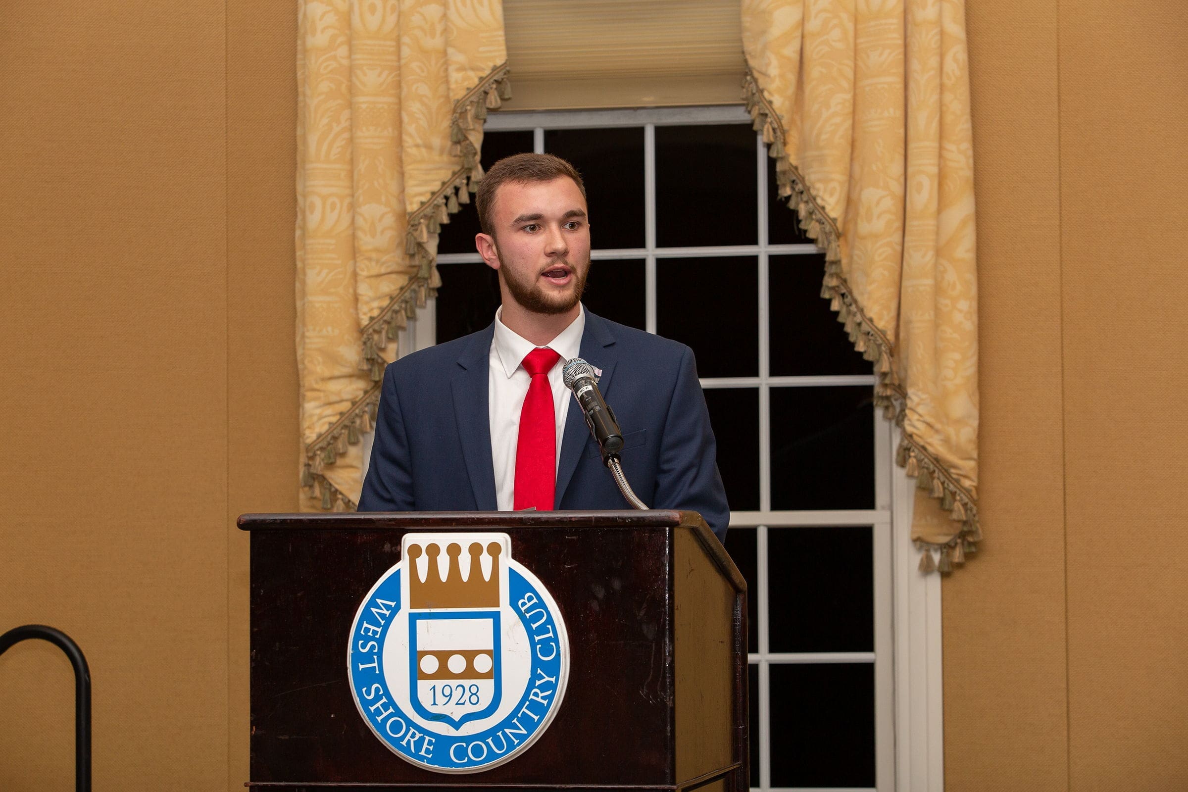 Young man speaking at West Shore Country Club event.