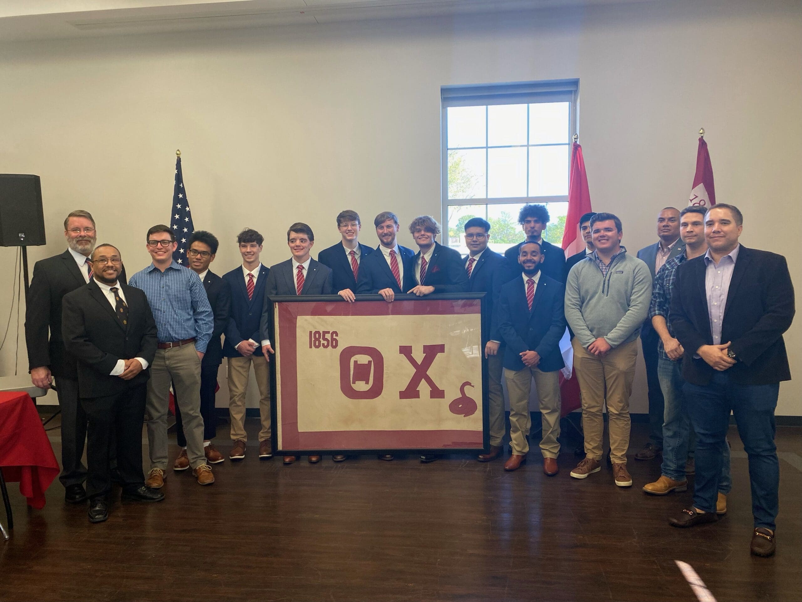 Group photo with fraternity members and banner.