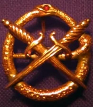 Golden emblem with crossed swords and snakes.