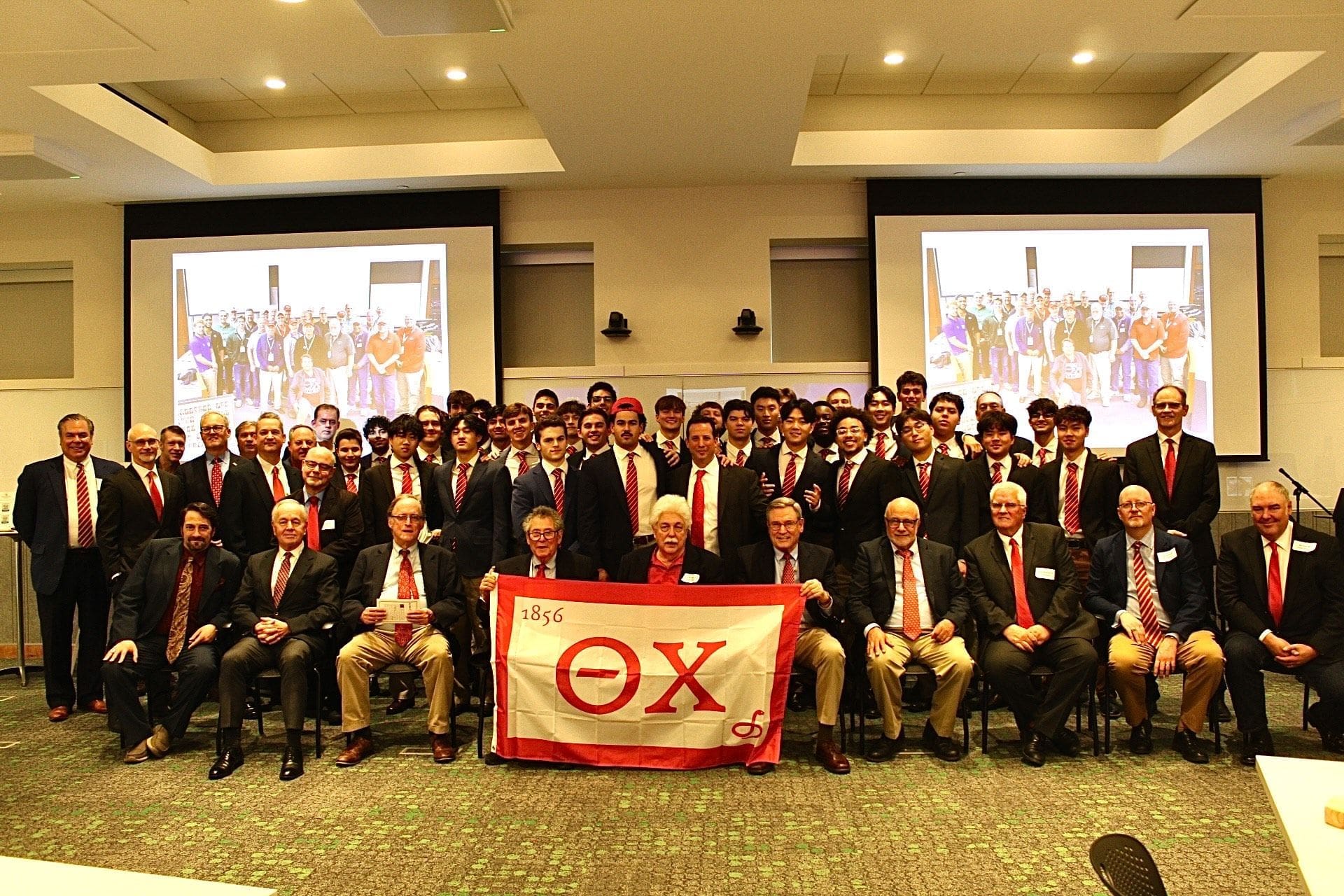 Group photo of fraternity members with flag.