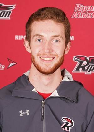 Smiling athlete in team jacket on red background.