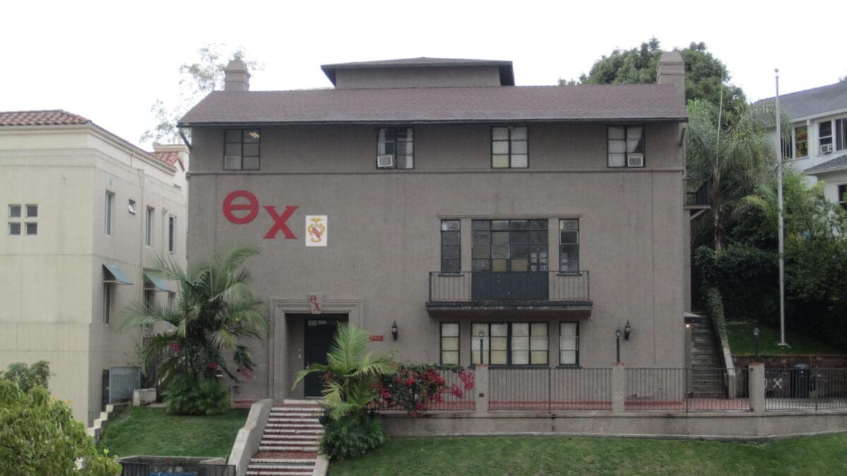 Gray building with red logo and balcony.