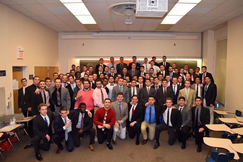 Group of young men in suits at event.