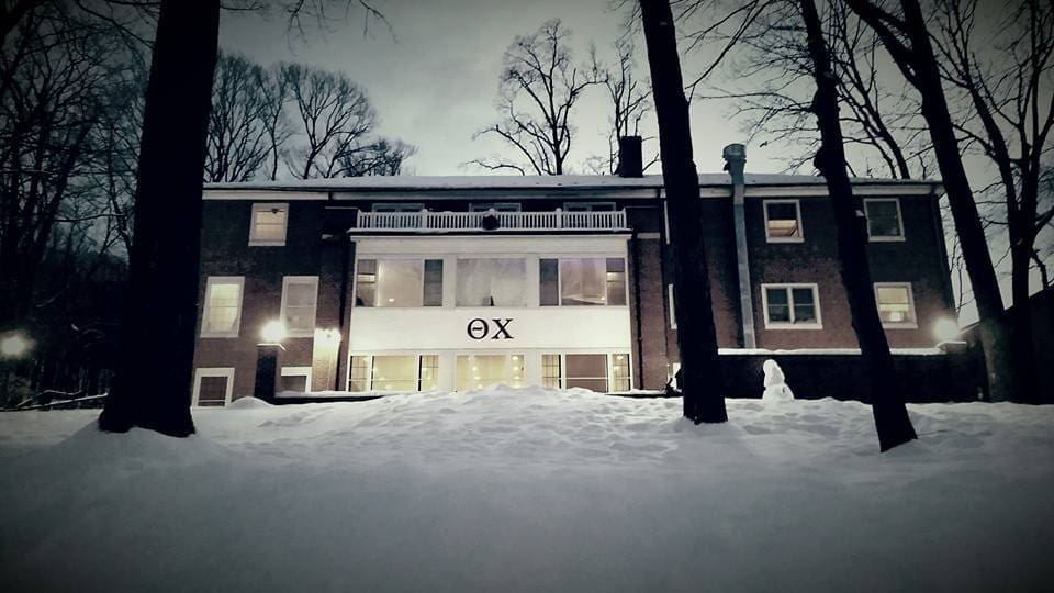 Snow-covered building with modern architecture at dusk.
