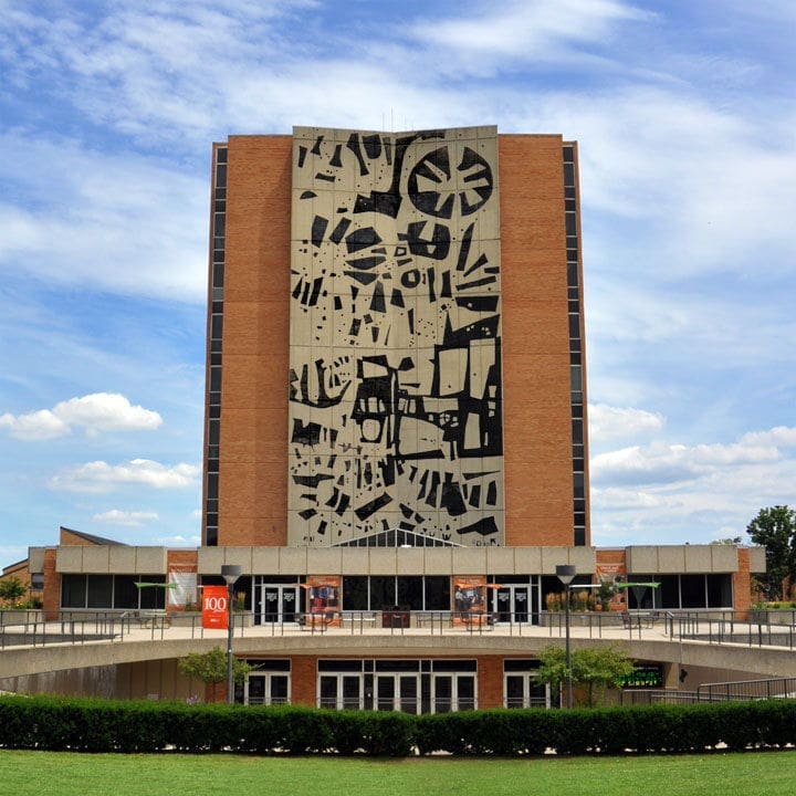 Modern building with abstract mural and blue sky.