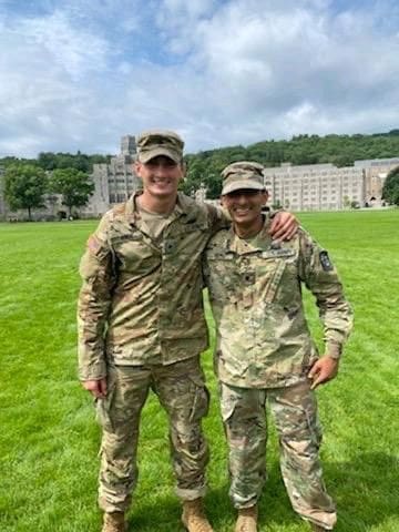 Bhavan Patel Two soldiers smiling on a grassy field.